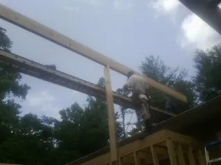 Carpenter setting a ridge beam over a new addition frame — Ice Dam Removal by Roofing Brothers in Hyrum