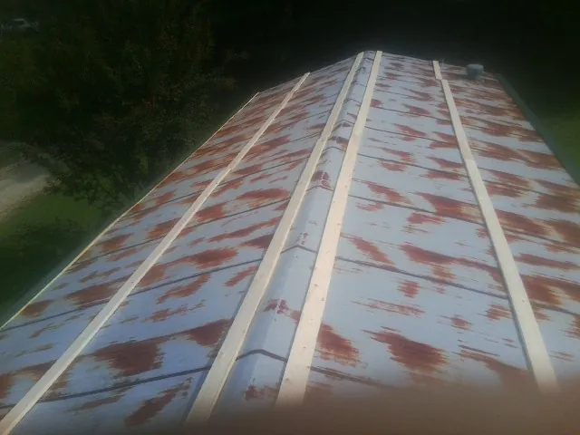 Rusted metal roof panels with new wood purlins before replacement — Storm Damage Roof Repair in Hyrum by Roofing Brothers