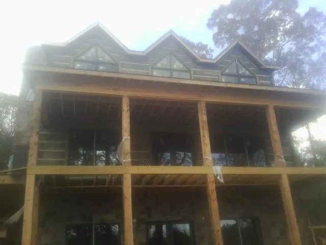 Dormers and porch framing on a large log home under construction — Roof Coating work by our crew in Hyrum